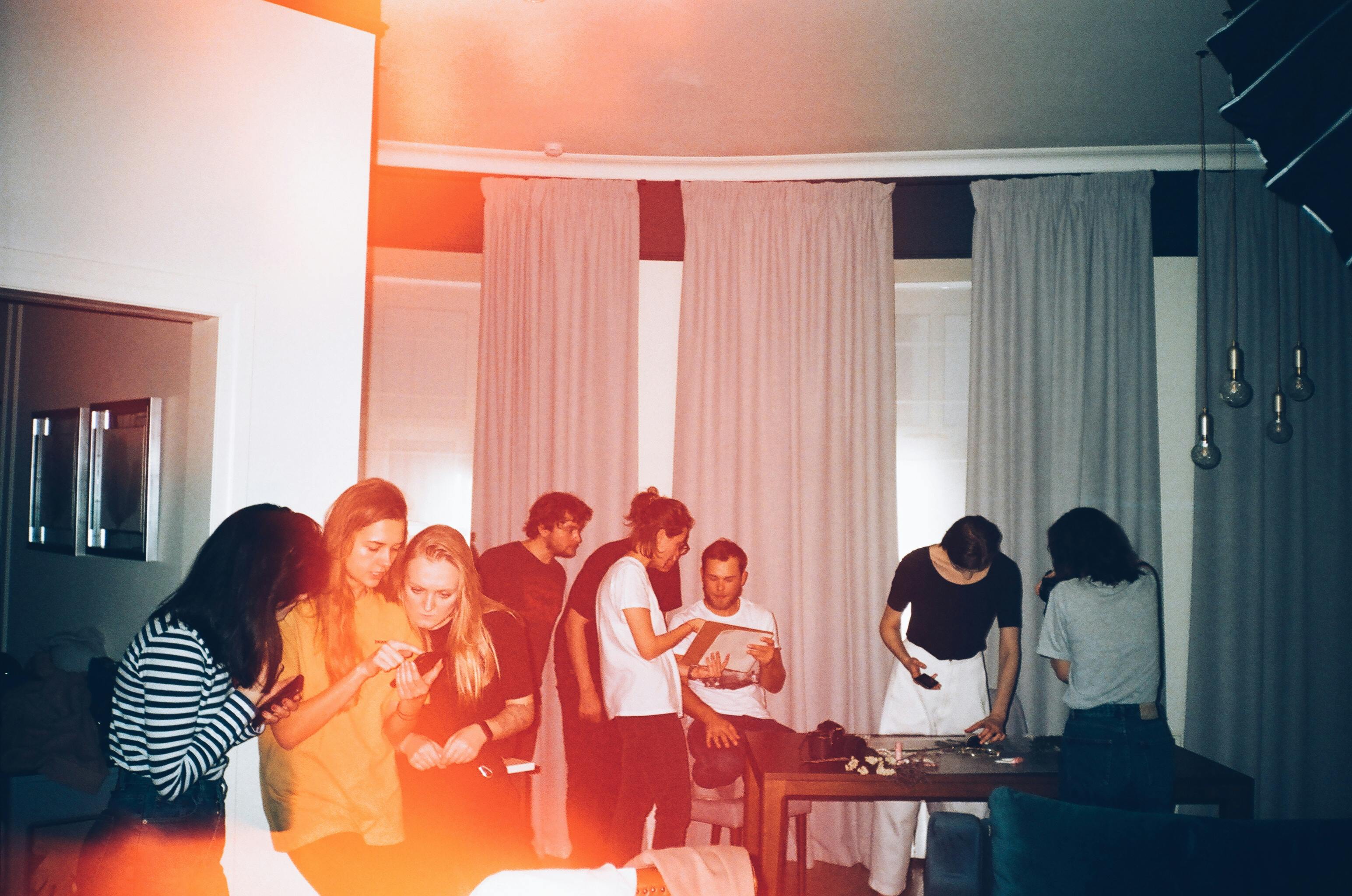 Friends gathered indoors in warm orange film photography light