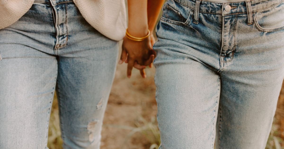 Two friends walking together down a sunlit path, close and genuine