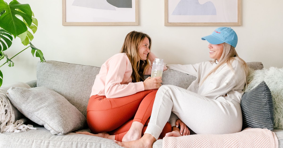 Two women sitting together on a couch, relaxed and comfortable