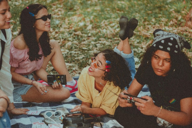 Young adults enjoying a picnic in New York City park while making friends in NYC.