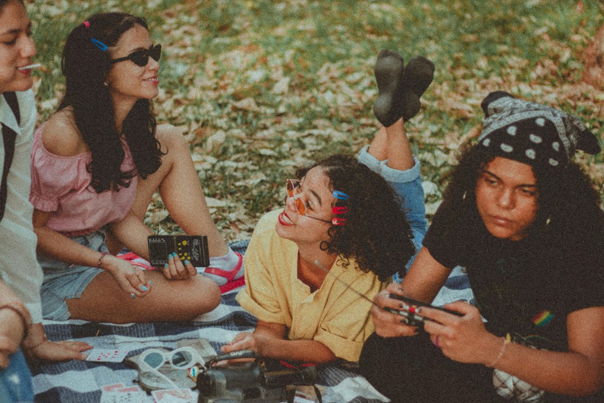 Young adults enjoying a picnic in New York City park while making friends in NYC.