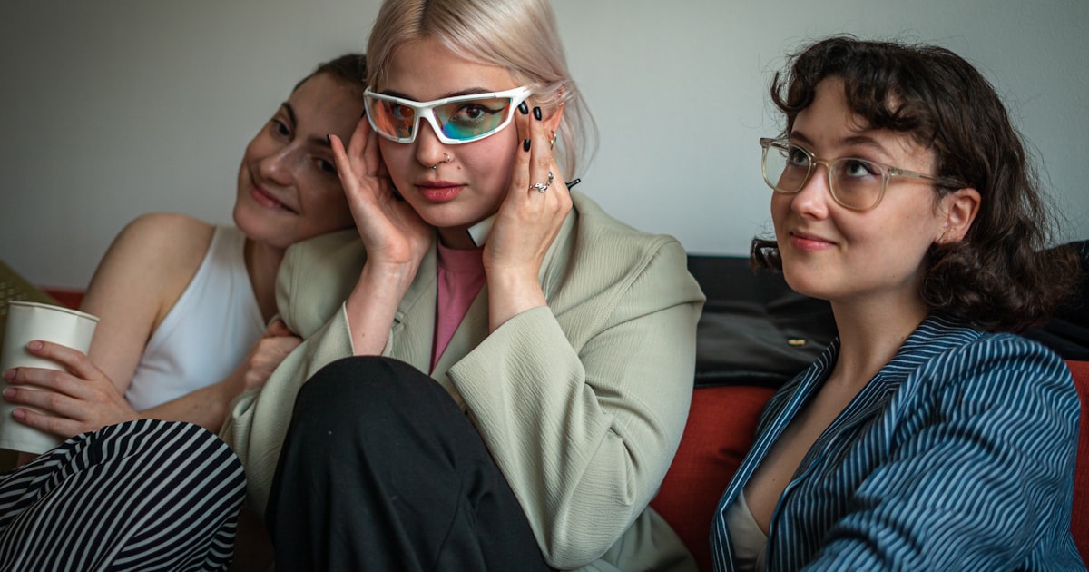 Three women with distinct styles posing together, different personalities connecting
