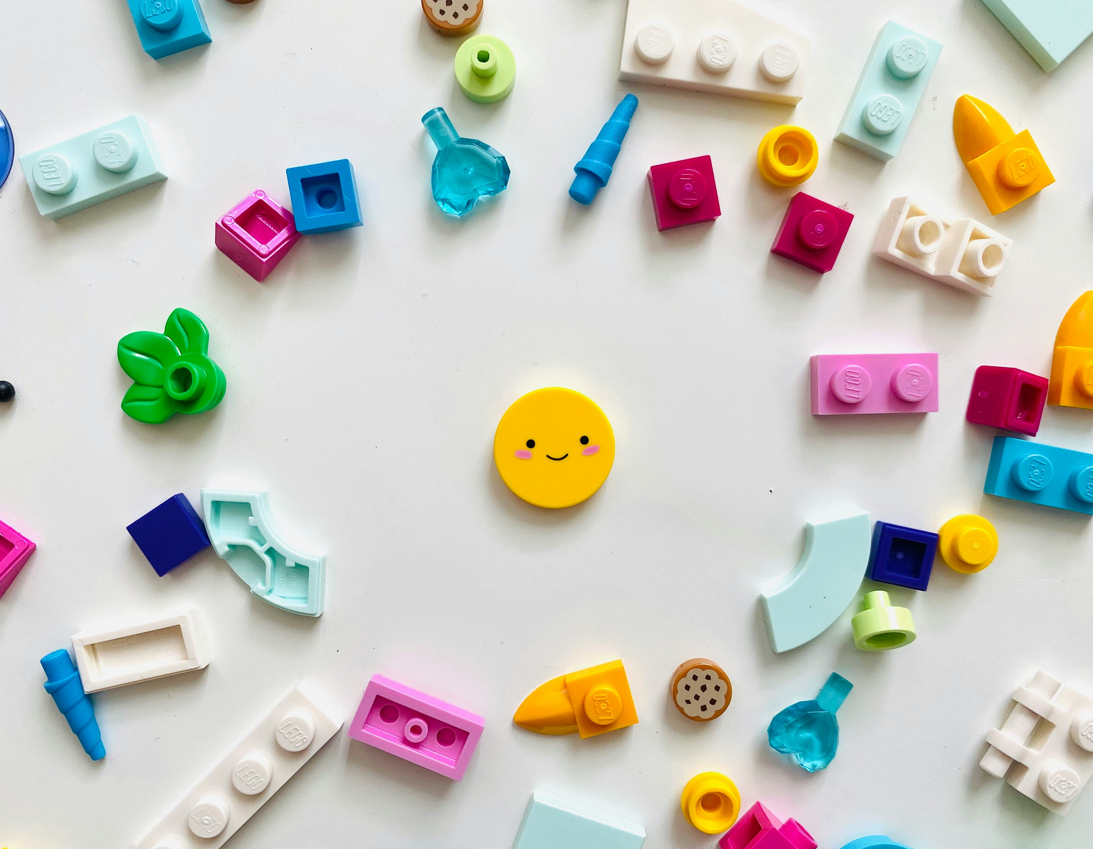 Colorful building blocks arranged in a circle with a smiling face in the center, representing social battery and energy management for introverts