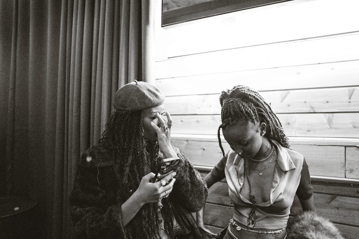Two women laughing indoors, black and white film photo